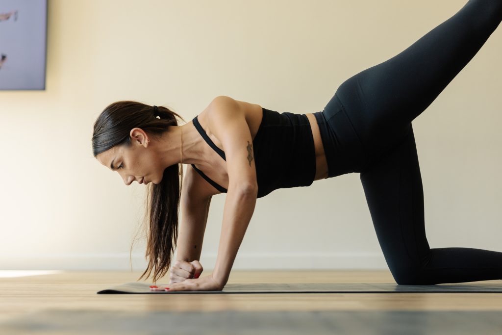 Woman practicing yoga-inspired stretches and movements for period pain at an FS8 studio